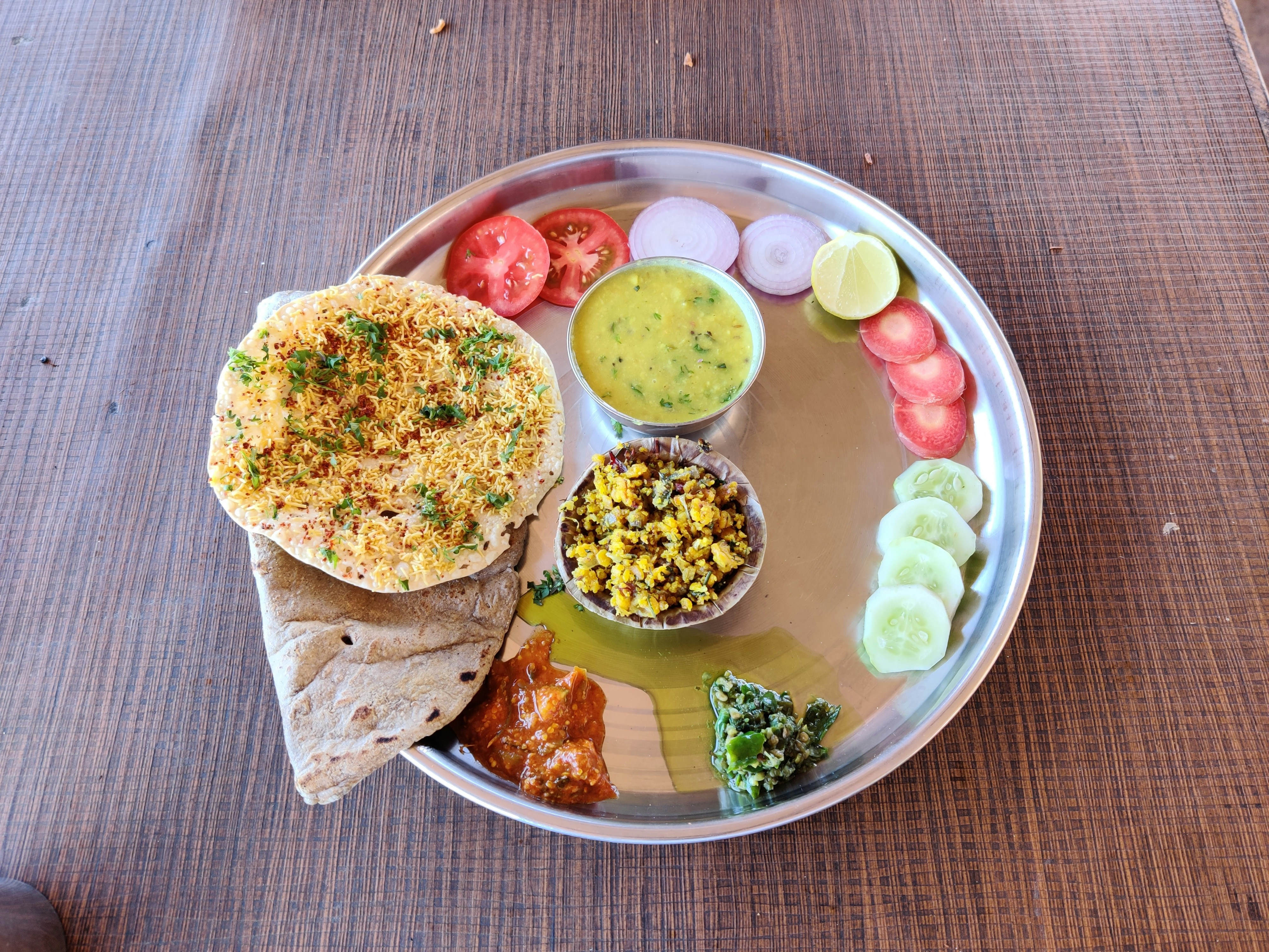 Dal tadka thali with rotis, rice, sabzi and salad on a steel plate