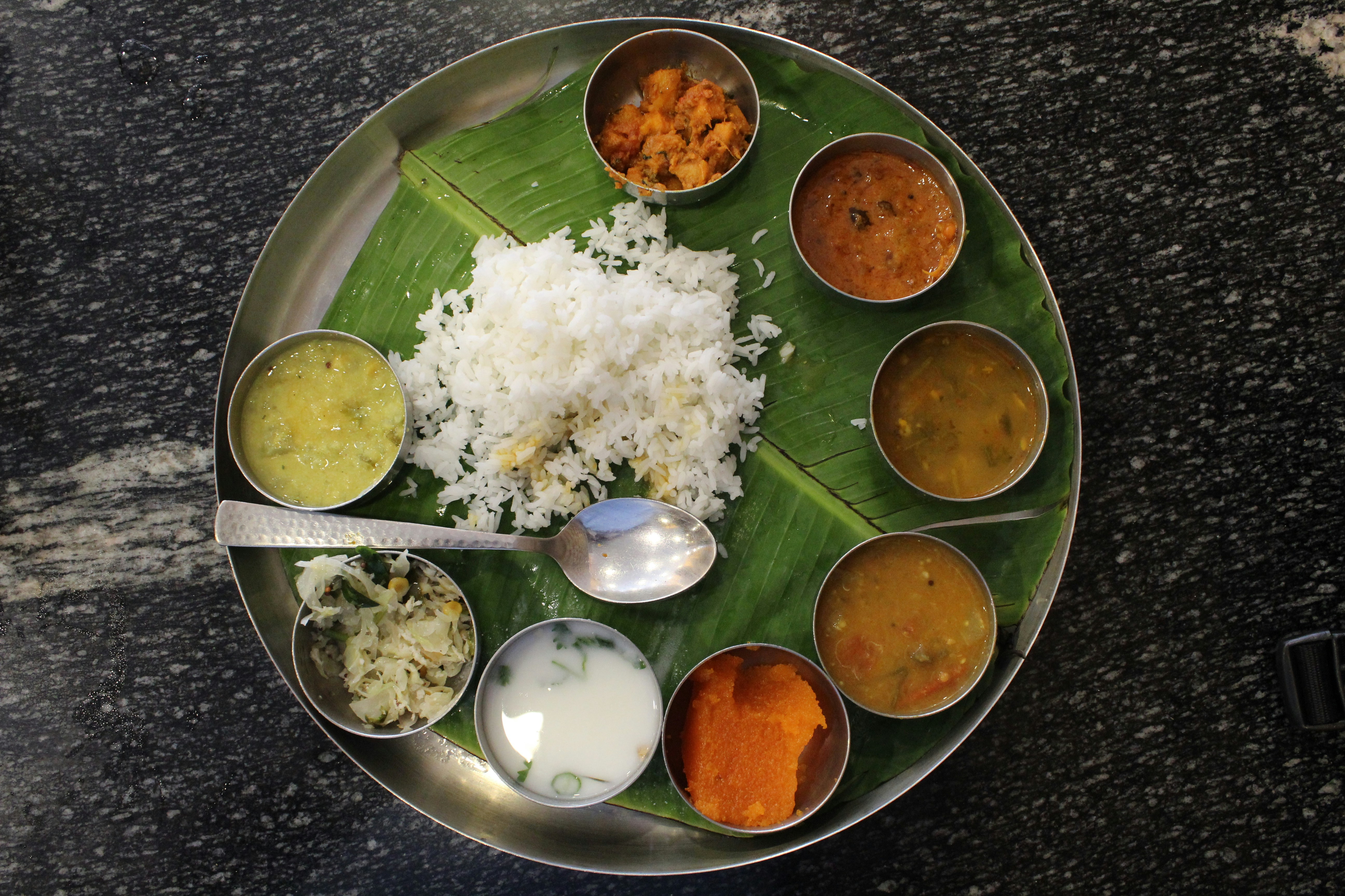 Freshly cooked Indian thali with colorful vegetables and rice served on banana leaf
